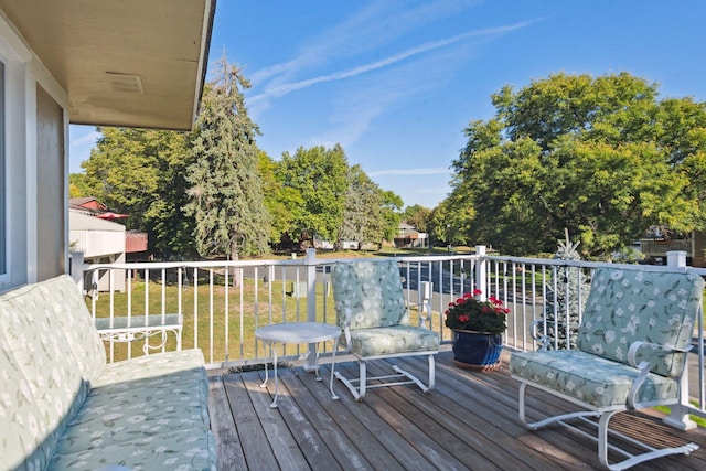 wooden terrace featuring a lawn