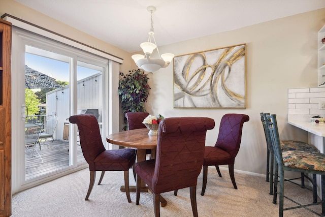 dining space with a notable chandelier and light carpet