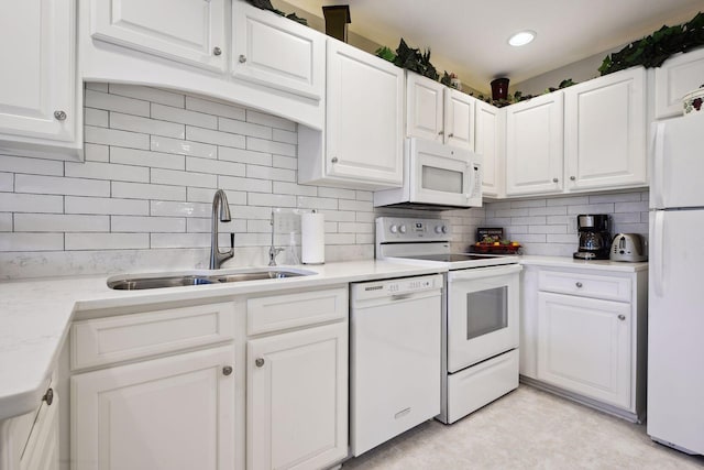 kitchen featuring decorative backsplash, white appliances, white cabinetry, and sink