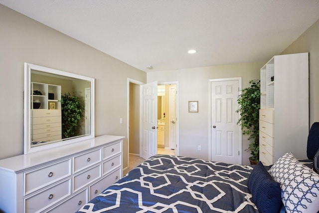 bedroom featuring light colored carpet and a textured ceiling