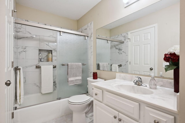 full bathroom featuring bath / shower combo with glass door, vanity, toilet, and tile patterned floors