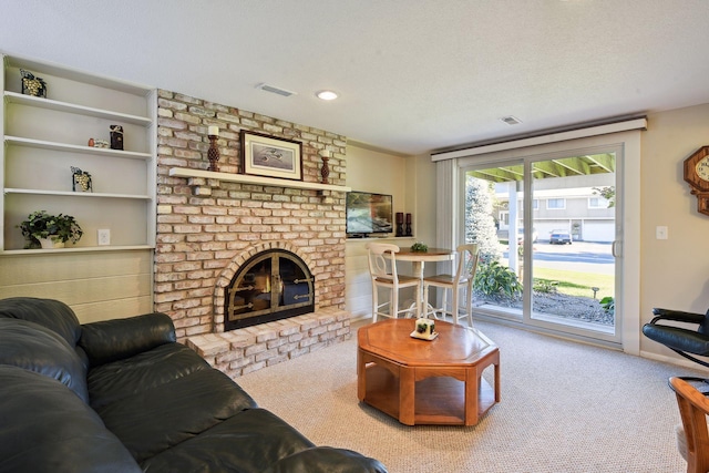 carpeted living room featuring a brick fireplace and a textured ceiling