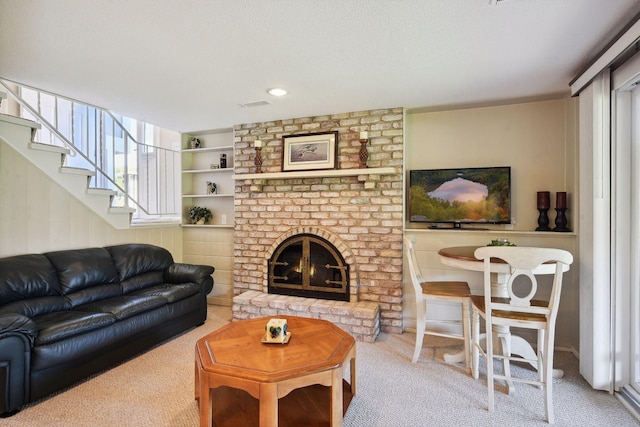 living room featuring a textured ceiling, a fireplace, and carpet flooring