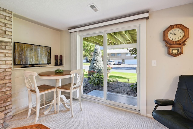 carpeted dining space featuring a textured ceiling