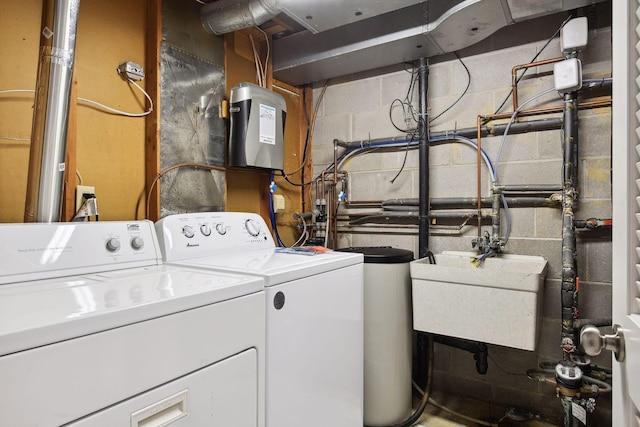 clothes washing area with washer and clothes dryer and sink