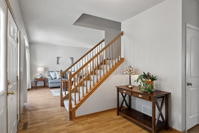 stairs featuring hardwood / wood-style flooring and a textured ceiling