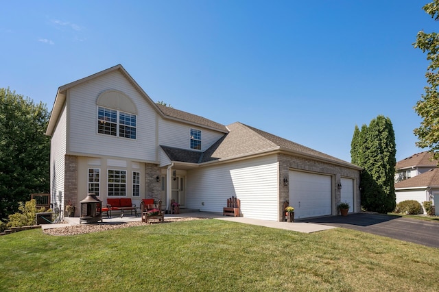 front facade featuring a fire pit, a garage, a patio area, and a front yard