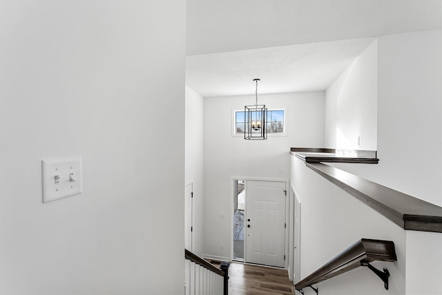 stairs featuring hardwood / wood-style flooring and an inviting chandelier