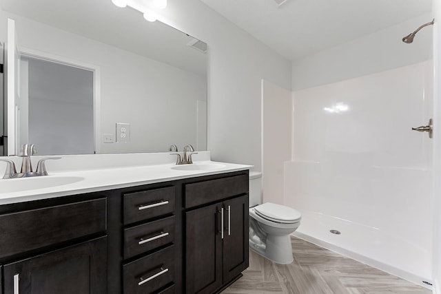 bathroom with walk in shower, vanity, toilet, and parquet floors