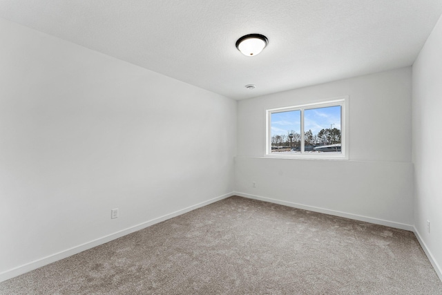 empty room with carpet flooring and a textured ceiling