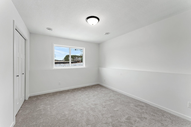 unfurnished room with carpet floors and a textured ceiling