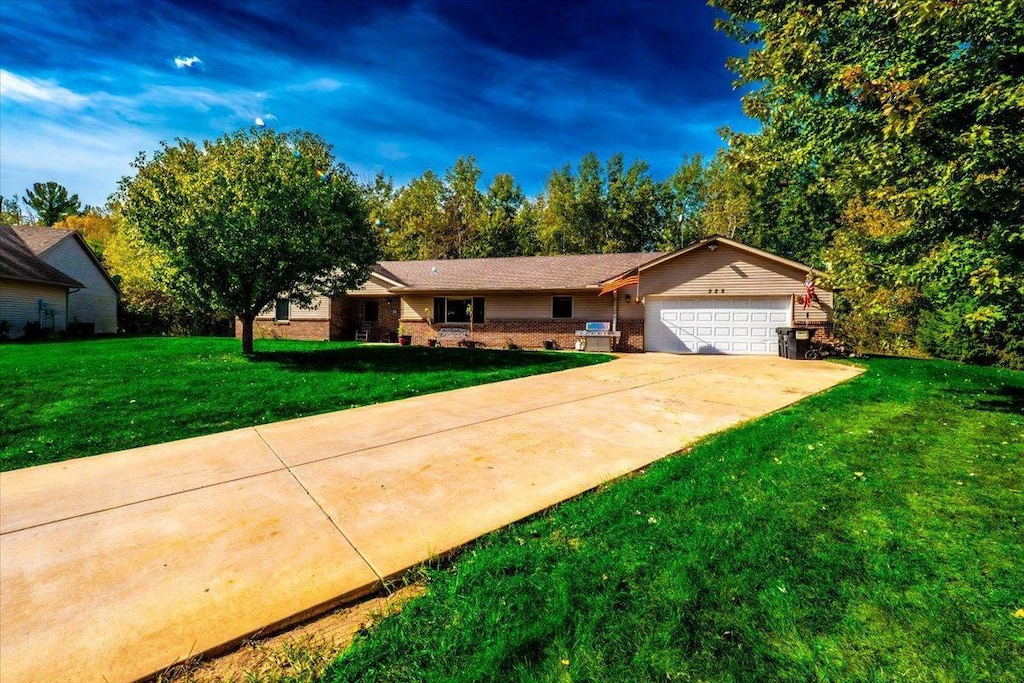 ranch-style house featuring a garage and a front yard