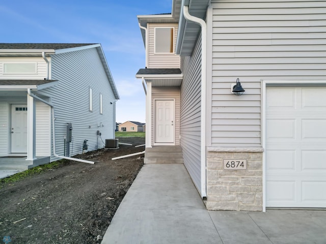 property entrance featuring a garage and central AC