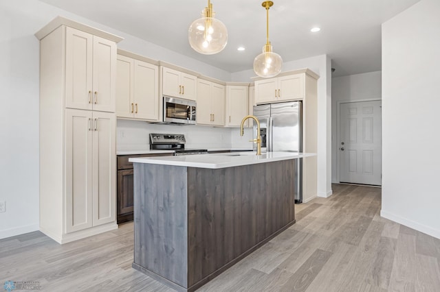 kitchen with stainless steel appliances, a sink, light wood-style floors, light countertops, and baseboards