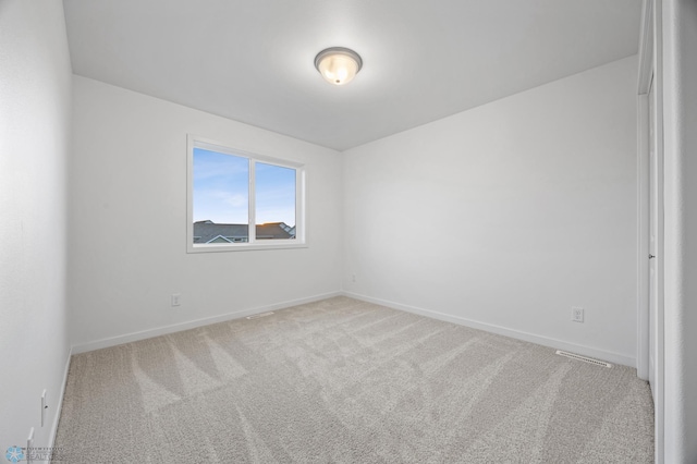 carpeted spare room featuring baseboards