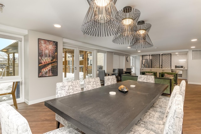 dining area featuring wood finished floors, a chandelier, baseboards, and recessed lighting