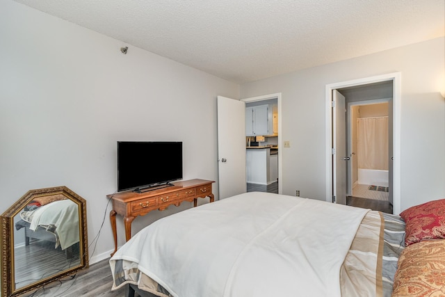 bedroom with a textured ceiling and wood finished floors