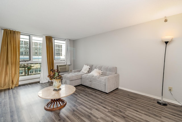 living room featuring cooling unit, wood finished floors, baseboards, and a baseboard heating unit