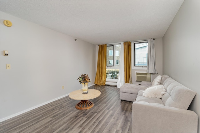 living area with wood finished floors, cooling unit, a textured ceiling, baseboards, and a baseboard heating unit
