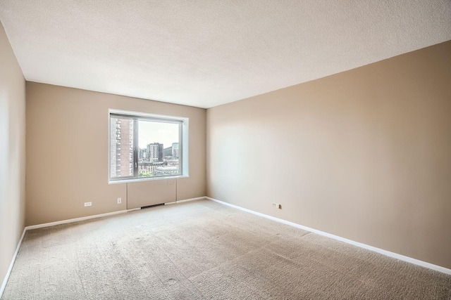 carpeted empty room featuring a textured ceiling