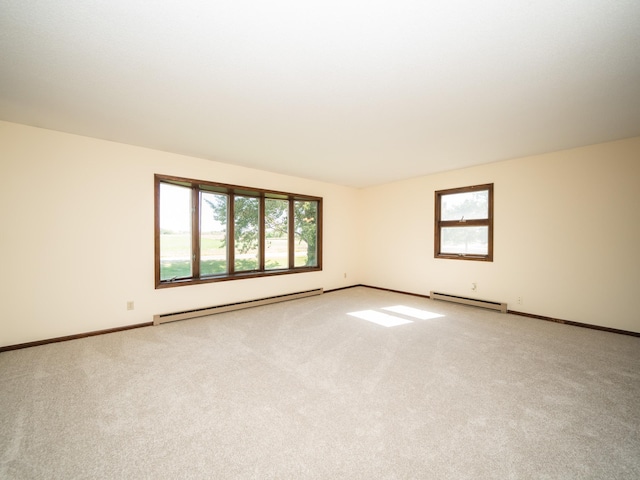 unfurnished room with light carpet and a baseboard heating unit