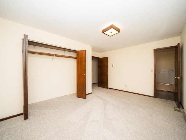 unfurnished bedroom with light colored carpet and a closet