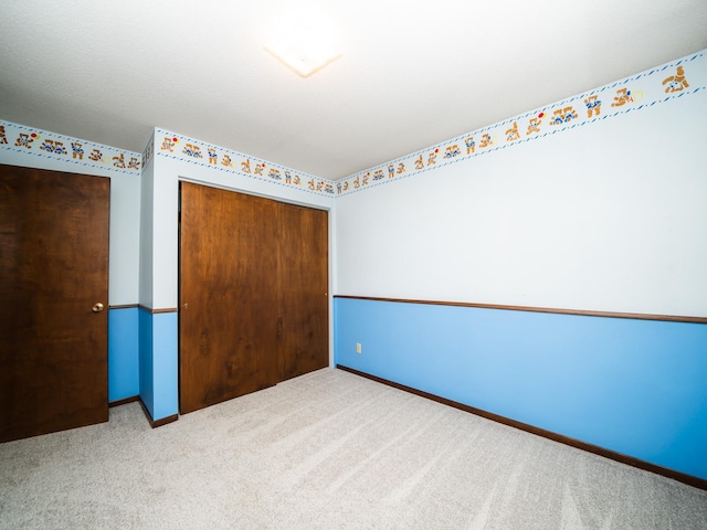 unfurnished bedroom featuring carpet floors and a closet