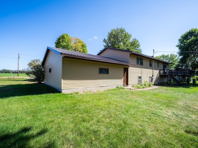 back of property featuring a yard and a deck