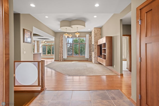 entryway with wood-type flooring and a stone fireplace