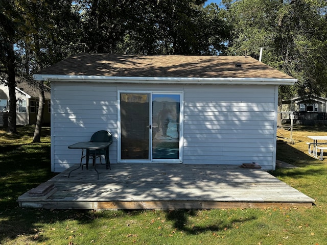 rear view of property featuring a lawn and a deck