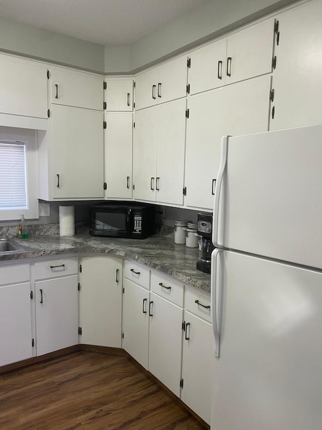 kitchen with white cabinetry, sink, white refrigerator, and dark hardwood / wood-style floors