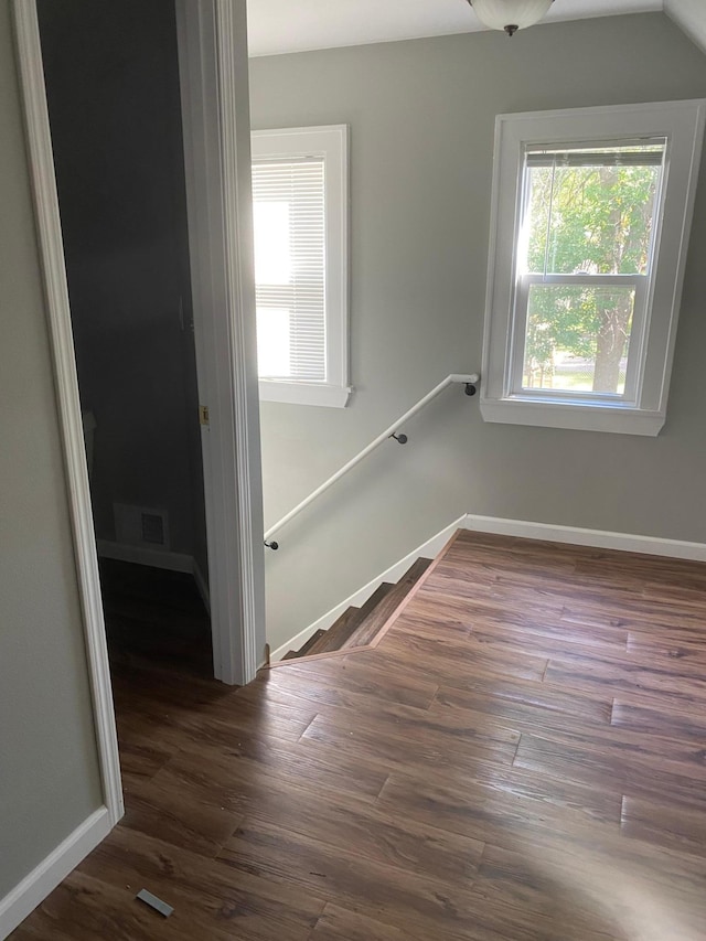 stairway with vaulted ceiling and hardwood / wood-style flooring