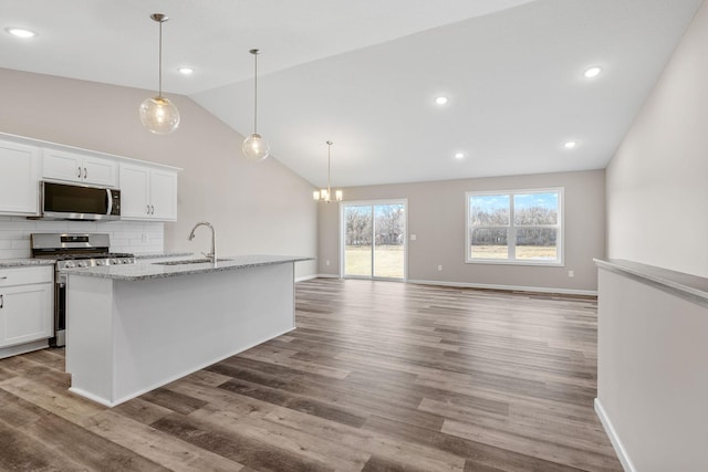 kitchen featuring sink, appliances with stainless steel finishes, tasteful backsplash, an island with sink, and white cabinets