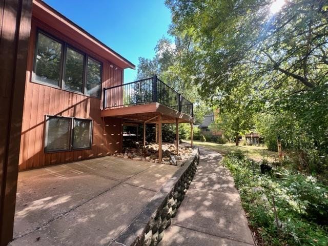 back of property featuring a patio and a wooden deck