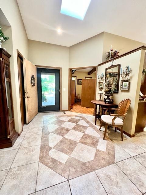 interior space with a skylight and light tile patterned floors