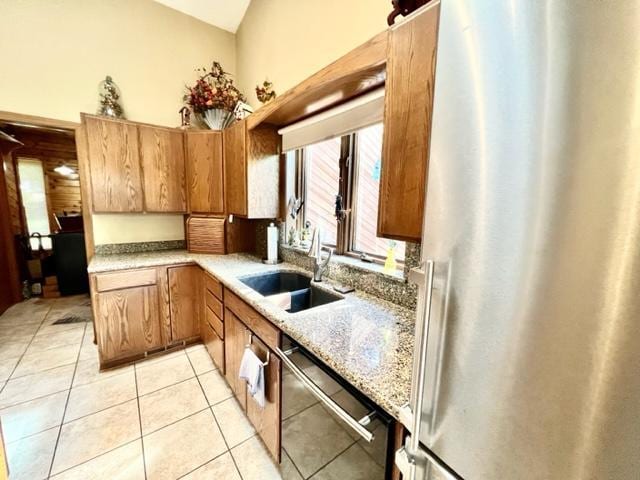 kitchen with light tile patterned floors, appliances with stainless steel finishes, and sink