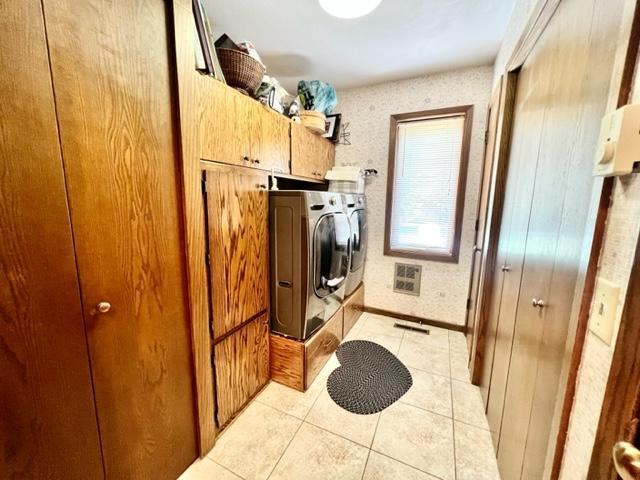 washroom with cabinets, light tile patterned flooring, and separate washer and dryer