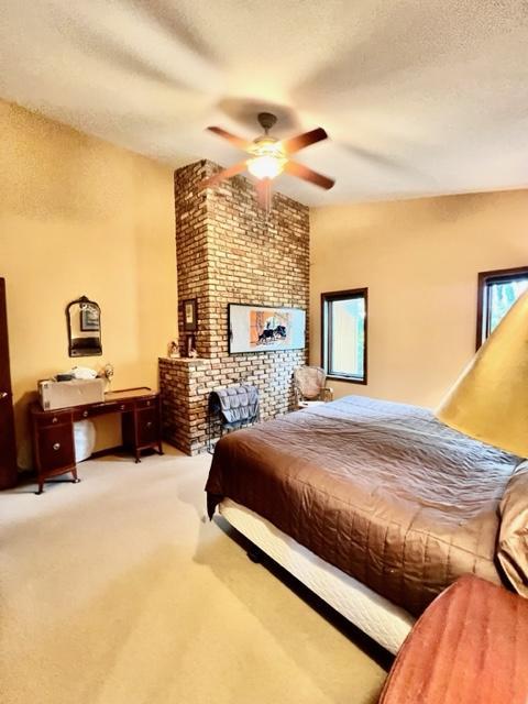 carpeted bedroom featuring a textured ceiling and ceiling fan