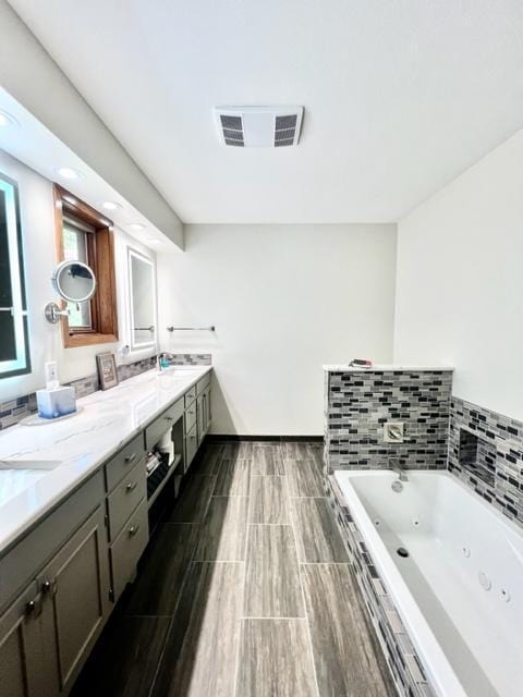 bathroom with hardwood / wood-style flooring, vanity, and a bathing tub