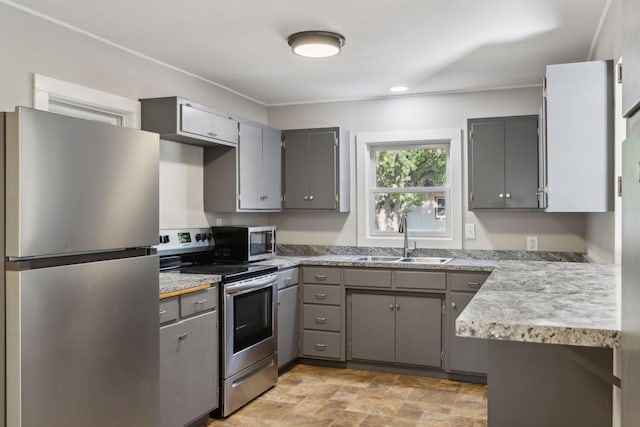 kitchen with appliances with stainless steel finishes, gray cabinetry, and sink