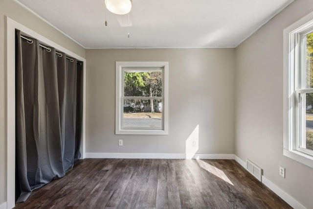 spare room with crown molding, ceiling fan, and dark wood-type flooring