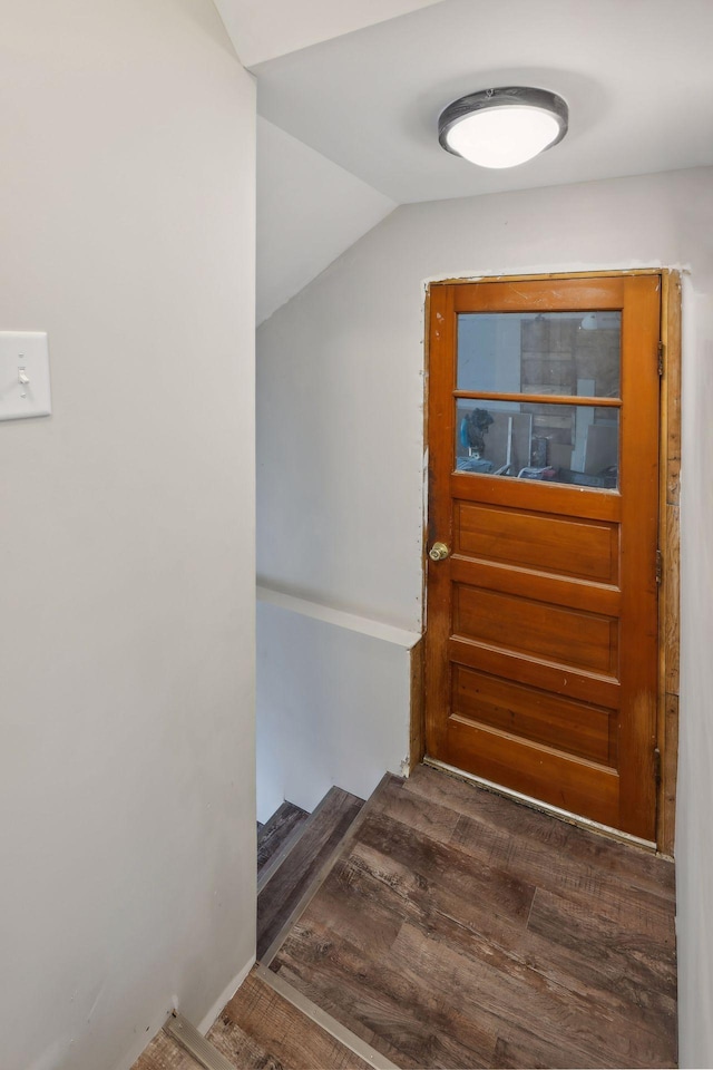 doorway featuring vaulted ceiling and dark hardwood / wood-style flooring