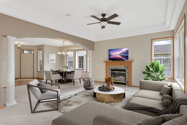 living room featuring a fireplace and ceiling fan with notable chandelier