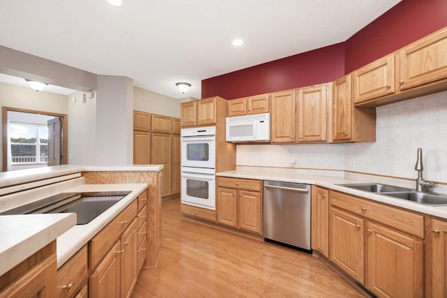 kitchen with white appliances, tasteful backsplash, light hardwood / wood-style floors, and sink