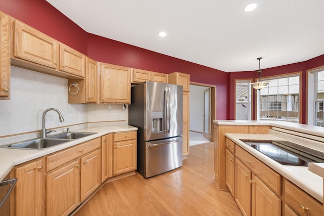 kitchen with backsplash, sink, light wood-type flooring, decorative light fixtures, and stainless steel fridge with ice dispenser