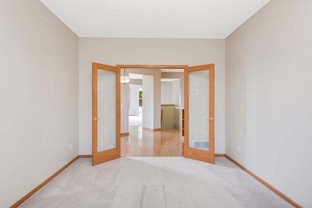 carpeted empty room featuring french doors