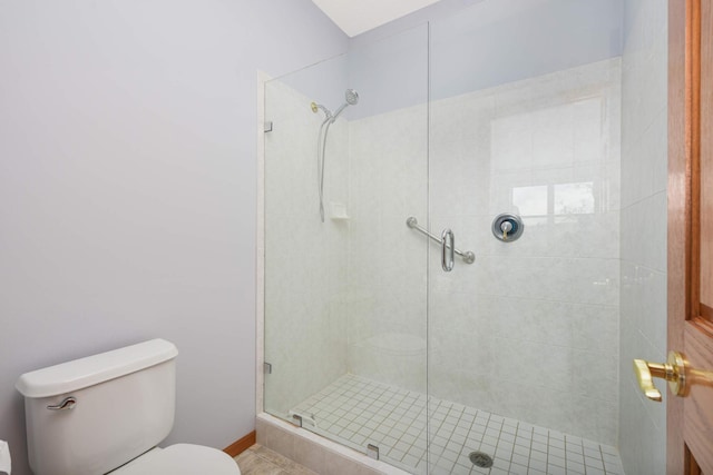 bathroom featuring walk in shower, tile patterned flooring, and toilet