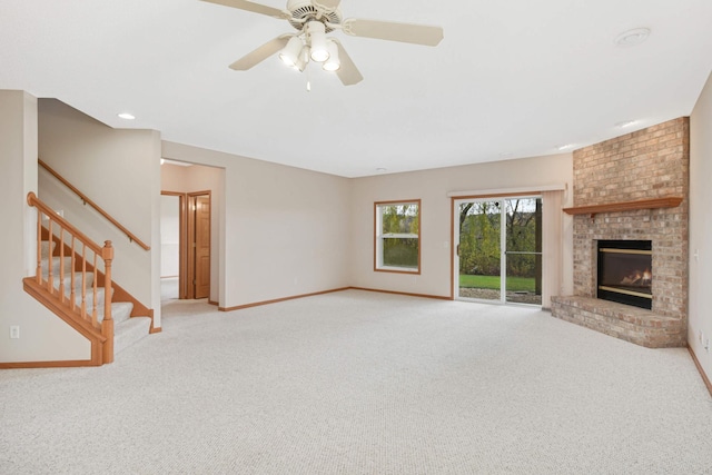 unfurnished living room featuring a fireplace, light carpet, and ceiling fan