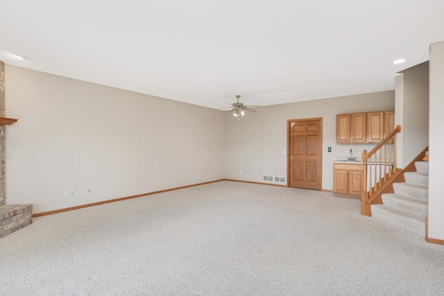 unfurnished living room with ceiling fan and light colored carpet