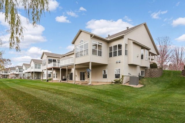 rear view of house featuring a lawn and central AC